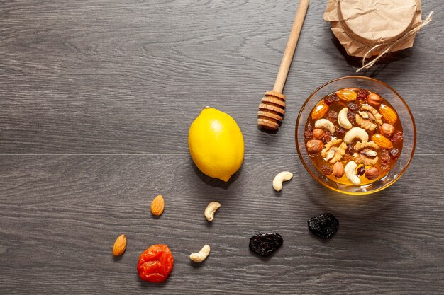 Top view honey stick and bowl with nuts