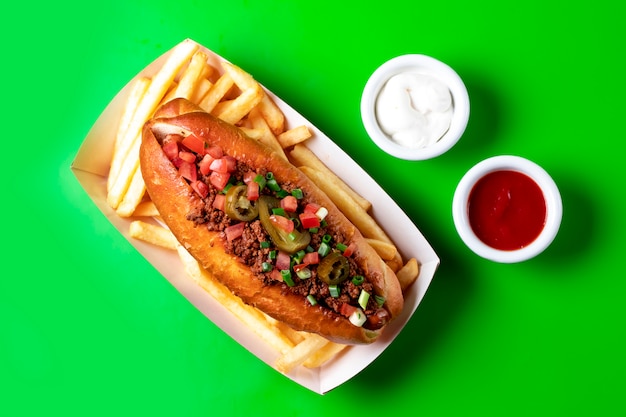 Top view of hot dog with minced meat tomato scallion and pickled jalapeno