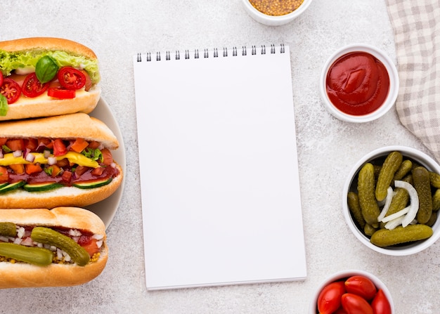 Free photo top view hot dogs and notebook