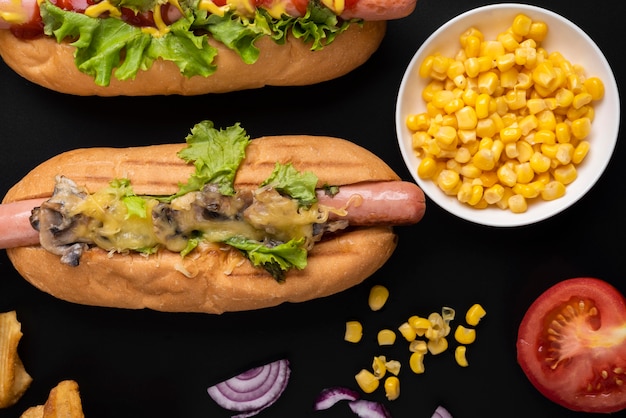 Top view of hot dogs with salad and corn