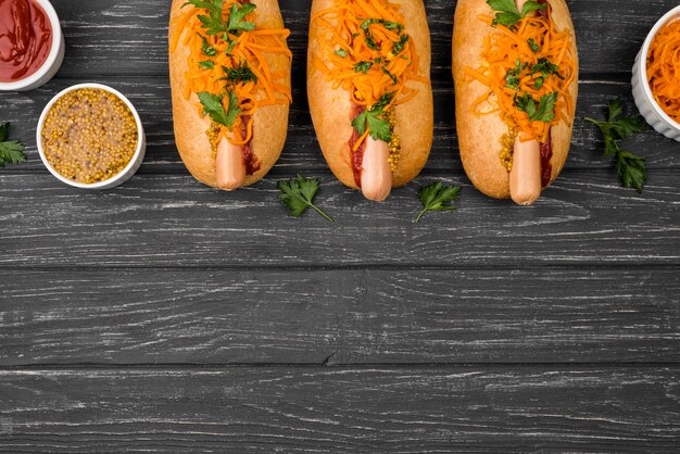 Top view hot dogs on wooden background