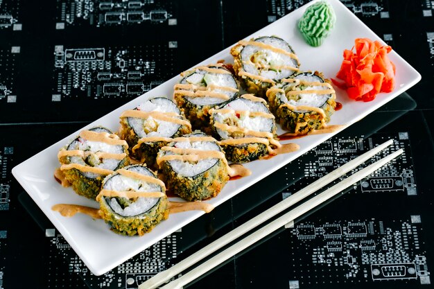 Top view of hot sushi rolls with avocado and crab stick garnished with spicy mayonnaise