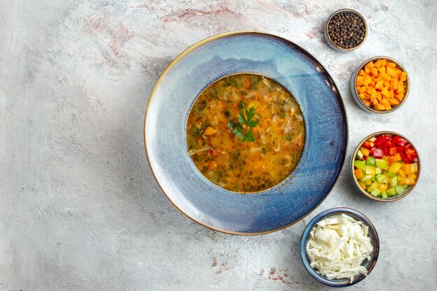 Top view hot vegetable soup inside plate on a light white space