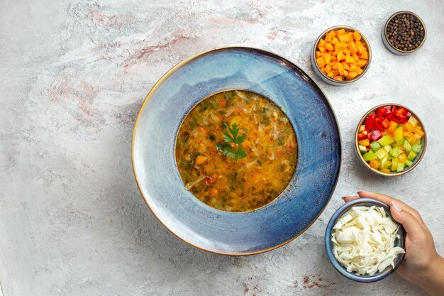 Top view hot vegetable soup inside plate on a light white space