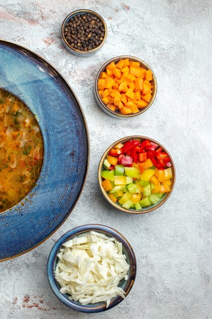 Вид сверху горячий овощной суп внутри тарелки на белом пространстве
