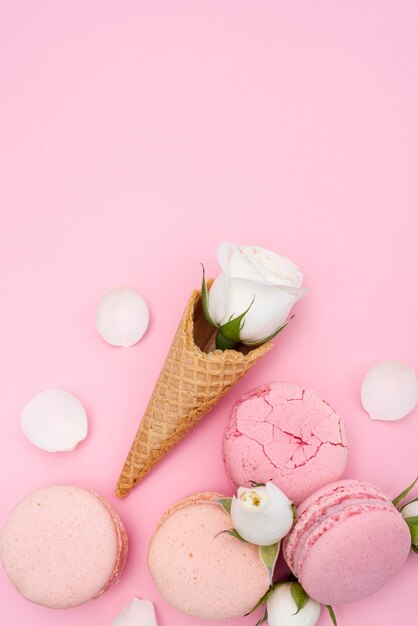 Top view of ice cream cone with rose and macarons