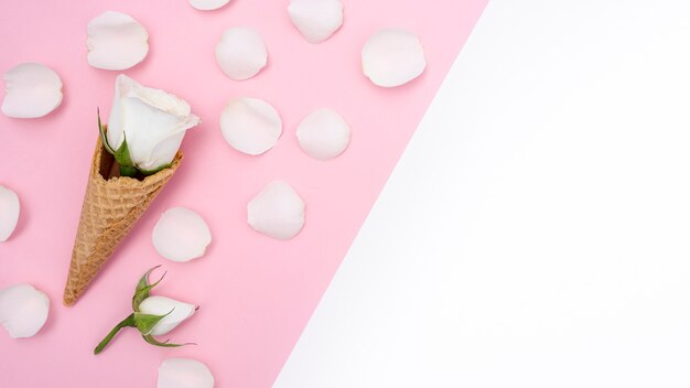 Top view of ice cream cone with roses and petals