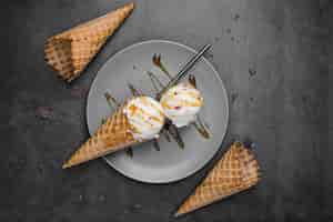 Free photo top view ice cream on cones on plate