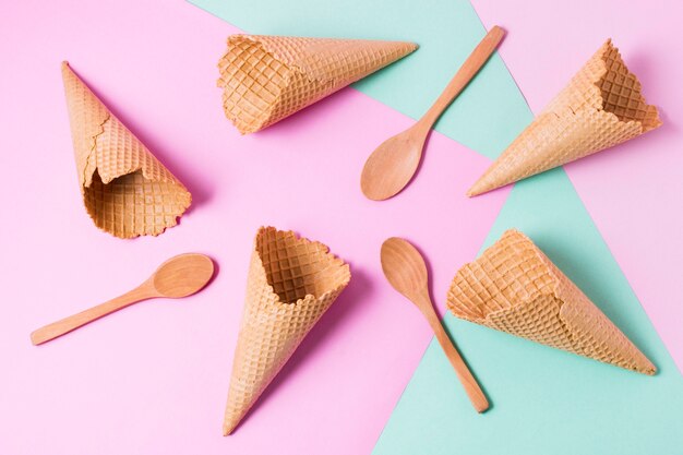 Top view ice cream cones and wooden spoons