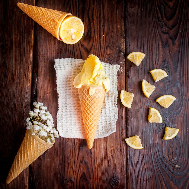 Free photo top view ice cream in a waffle cone with orange and gypsophila in rag napkins