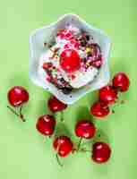 Free photo top view ice cream with chocolate and cherries on light green