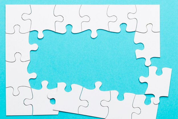 Top view of incomplete puzzle frame over blue backdrop