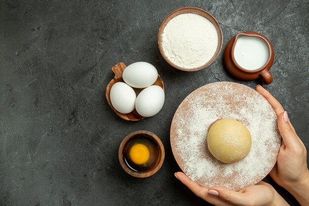 Top view ingredients for dough milk eggs flour on the grey space