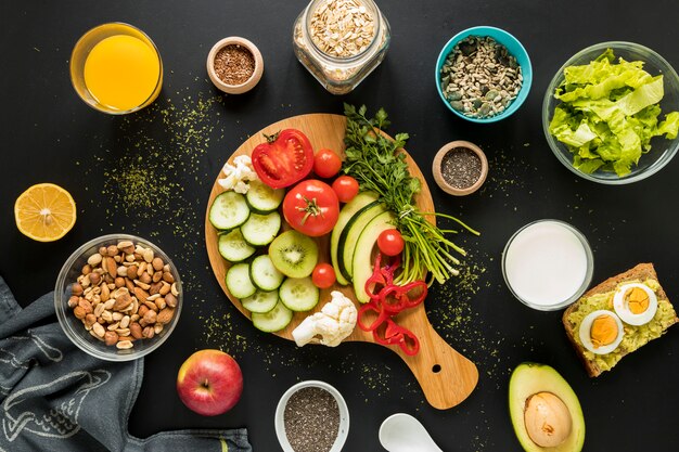 Top view of ingredients; dryfruits and vegetables on black background