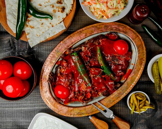 Top view of iskender kebab topped with pepper and tomato