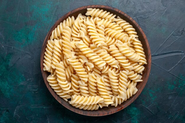 Top view italian pasta delicious looking inside brown pot on dark-blue surface italian pasta food meal dinner cooking kitchen dough