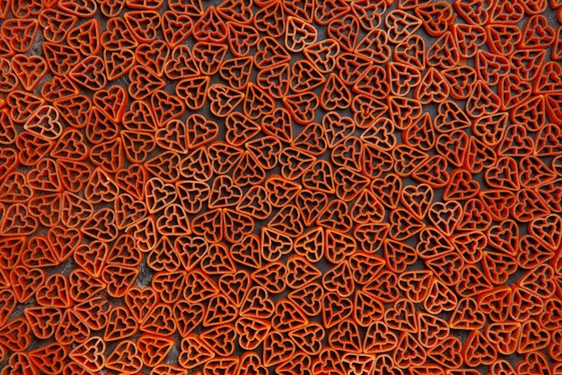 Top view italian pasta red hearts on dark table