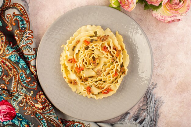 화려한 스카프와 분홍색에 회색 접시 안에 요리 야채와 작은 고기 조각과 상위 뷰 이탈리아 파스타 맛있는 식사