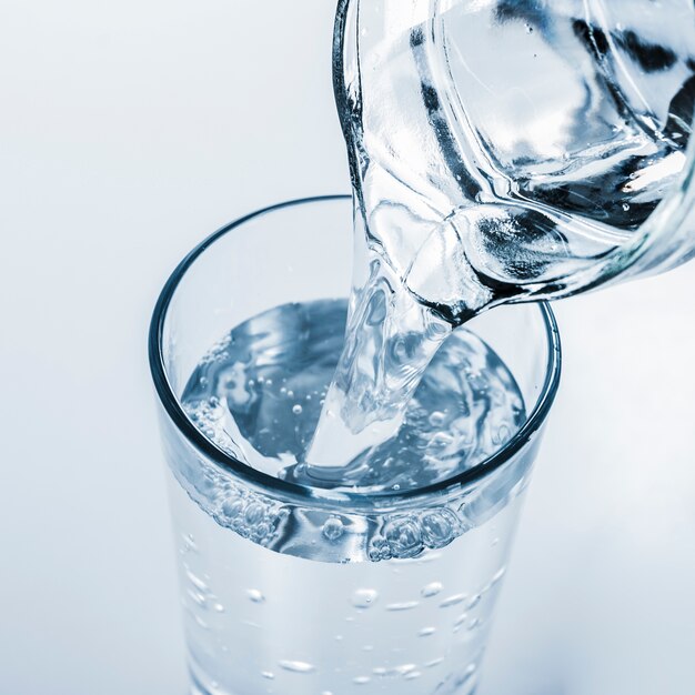 Top view jar filling glass of water