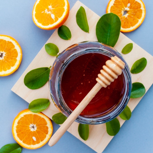 Free photo top view jar with honey and orange slices