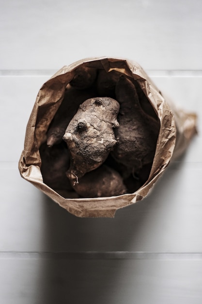 Top view of Jerusalem artichokes in a brown bag