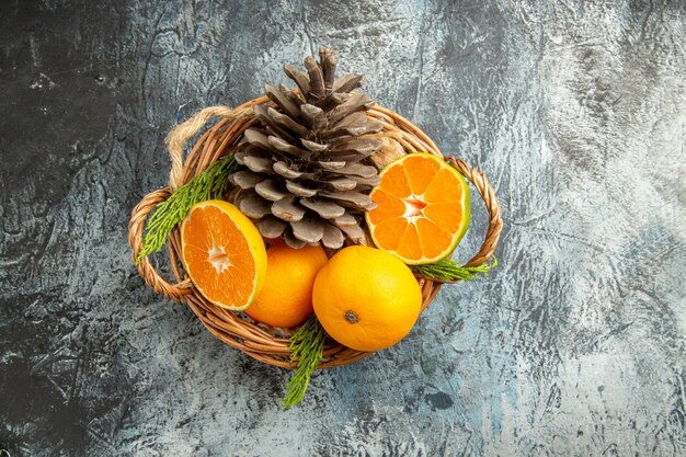 Top view of juicy fresh tangerines inside basket on light-grey surface