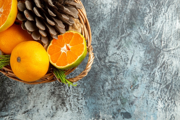 Free photo top view of juicy fresh tangerines inside basket on light-grey surface