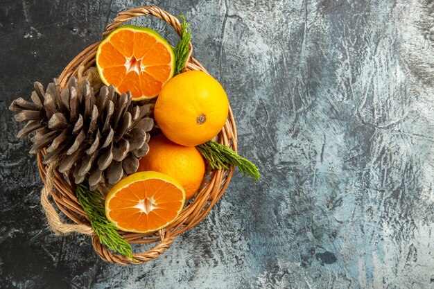 Top view of juicy fresh tangerines inside basket on light-grey surface