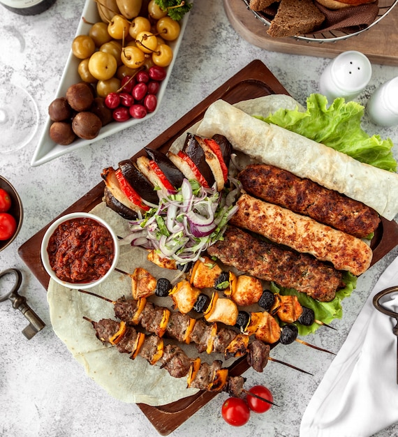 Top view of kebab platter on skewers served with salad