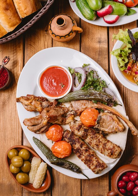 Top view of kebab platter with chicken vegetables lamb tikka and lula kebabs