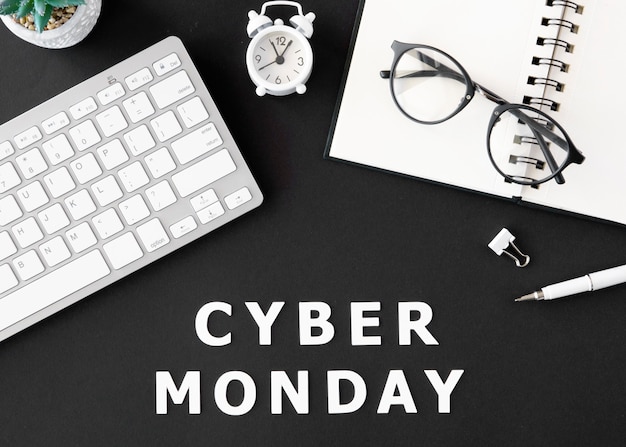 Free photo top view of keyboard with notebook and glasses for cyber monday