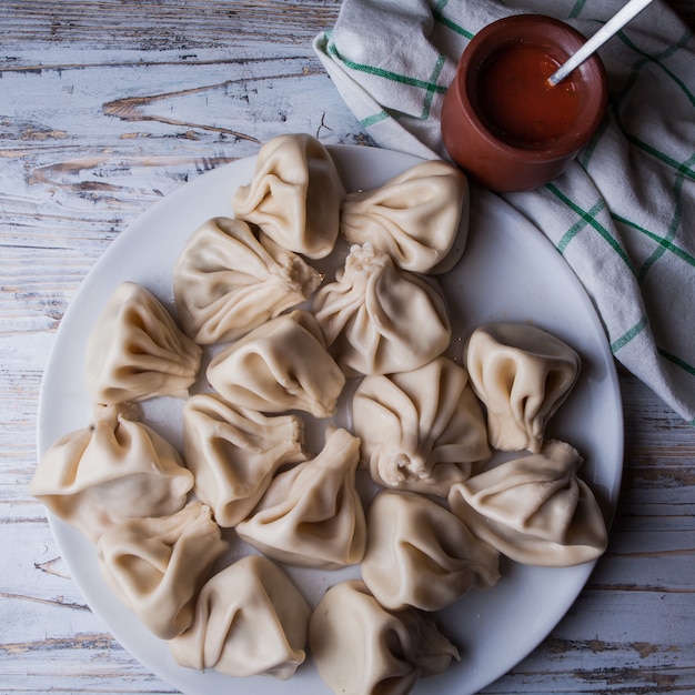 Top view khinkali with adjika and napkins in white plate