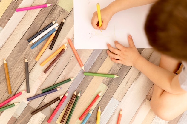 Top view kid drawing on floor