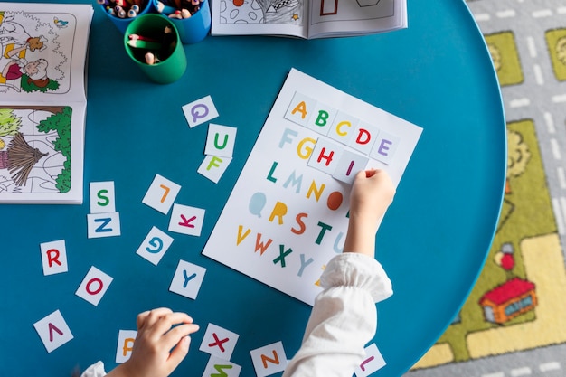 Foto gratuita lettere di apprendimento per bambini con vista dall'alto all'asilo