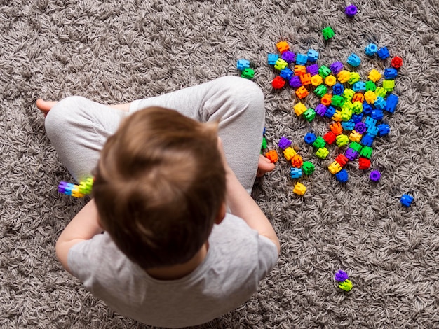 Top view kid playing with colorful game