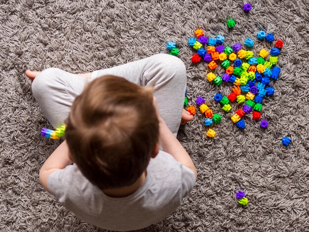 Top view kid playing with colorful game