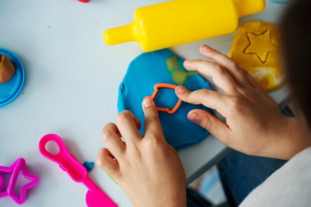 Top view kid playing with playdough