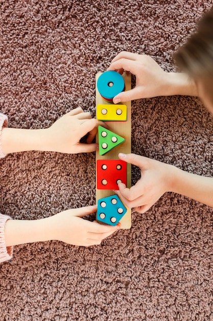 Free photo top view kids playing with wooden toy