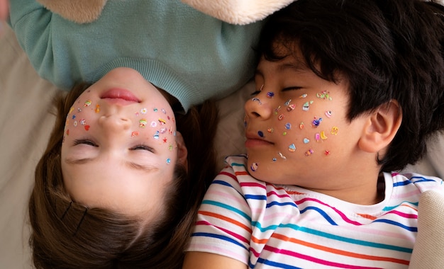 Foto gratuita bambini con vista dall'alto con adesivi sul viso