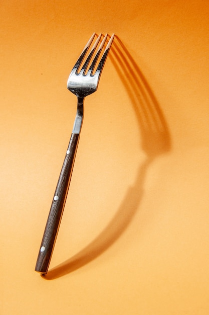 Top view of kitchen cutlery set leaning against the wall on golden background with free space