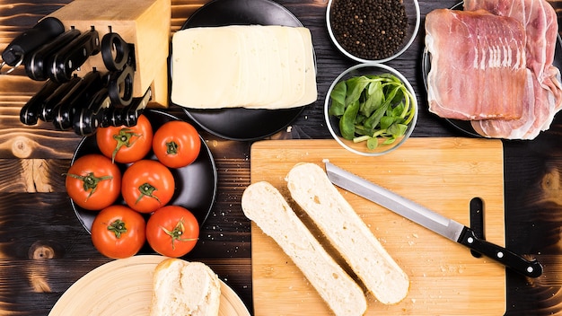 Top view on kitchen tables with a bread cut in two on wooden board