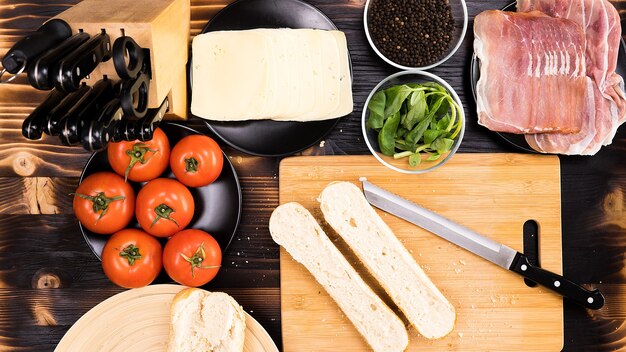 Top view on kitchen tables with a bread cut in two on wooden board