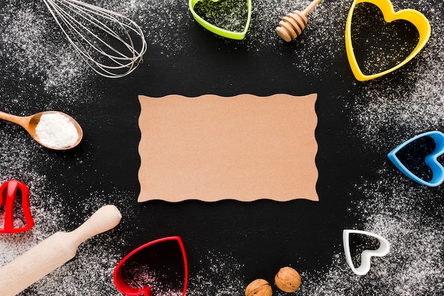 Top view of kitchen utensils and heart shapes with paper