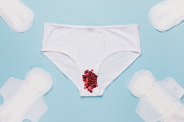 Free photo top view knickers with sequins and sanitary towels