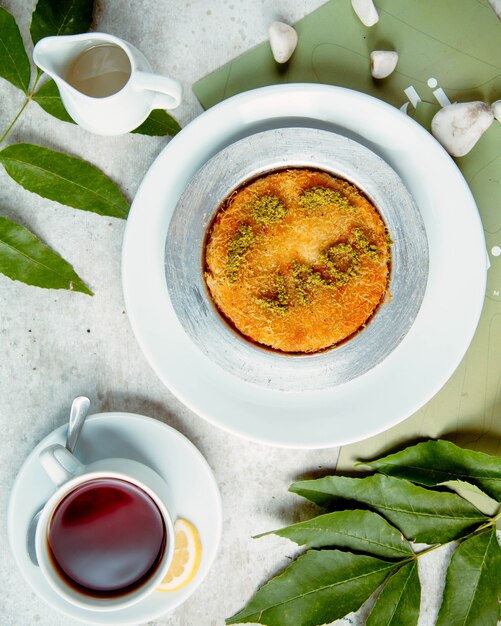 Top view of kunefe plate turkish dessert served with tea