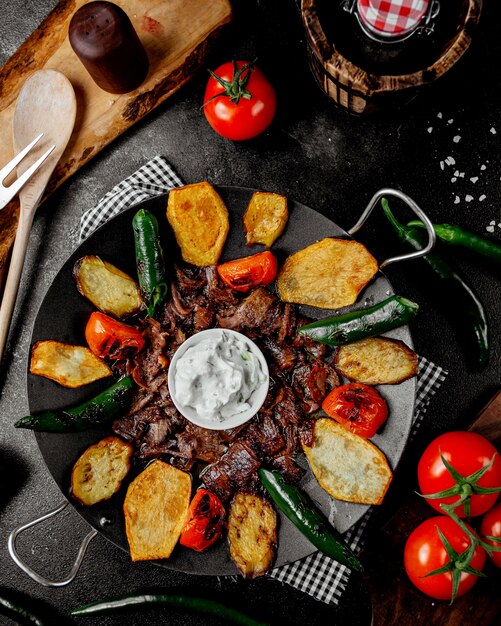 Top view of lamb saj kebab with potato pepper tomato