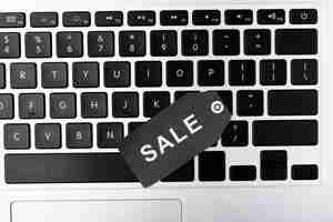 Free photo top view laptop keyboard with sale tag