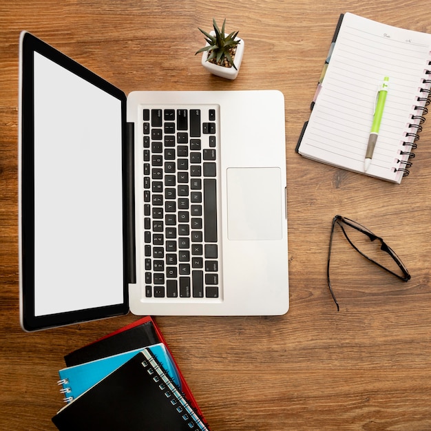 Top view of laptop and notebooks on office workspace