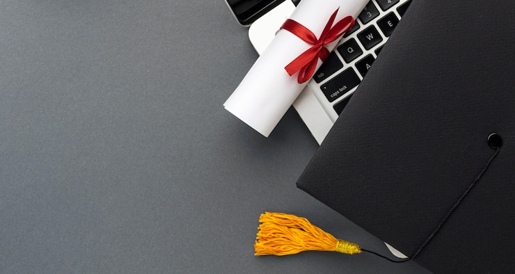 Free Photo top view of laptop with diploma and academic cap