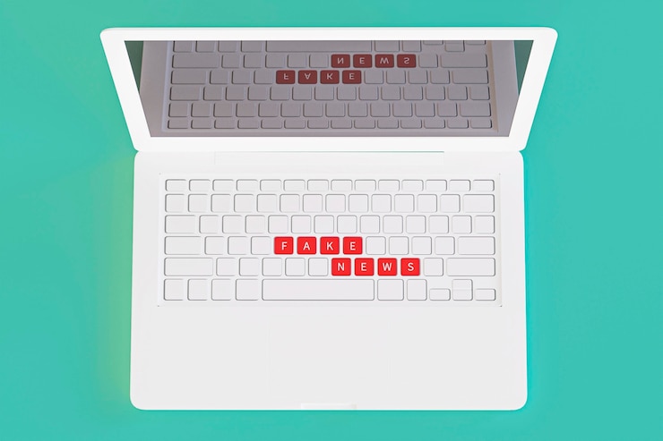 Free Photo top view of laptop with fake news on keyboard